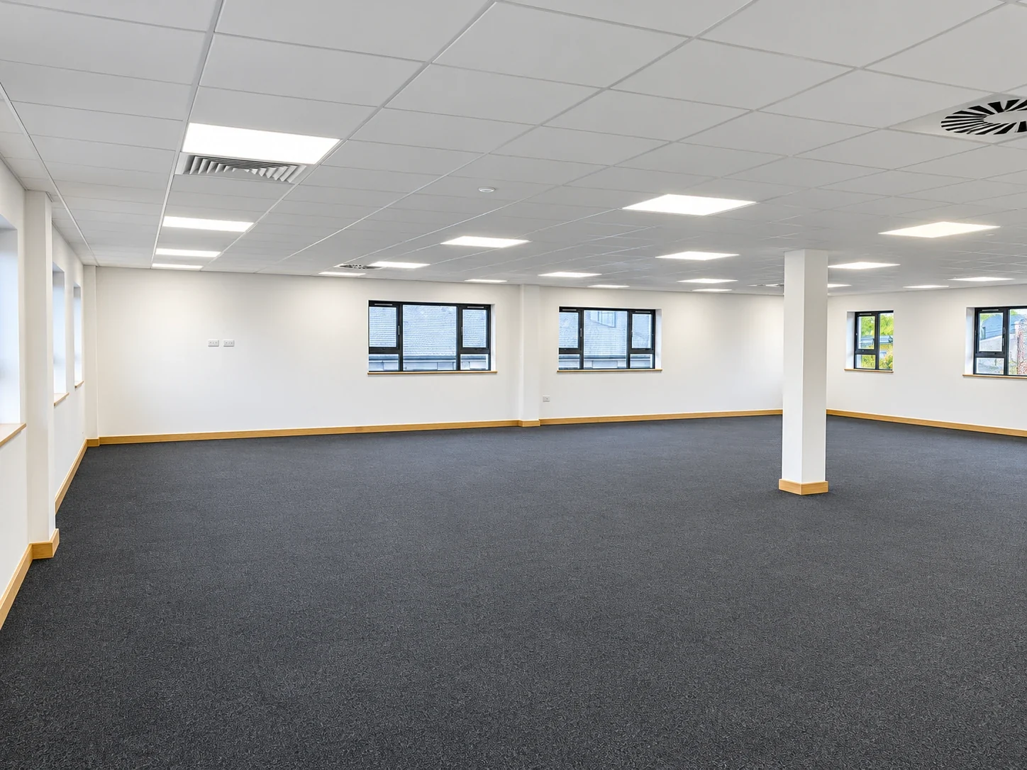 Open-plan office floor after dilapidations with new carpet tiles and reinstated ceiling lighting
