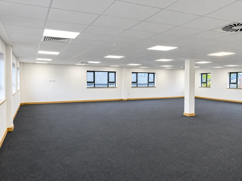 Open-plan office floor after dilapidations with new carpet tiles and reinstated ceiling lighting