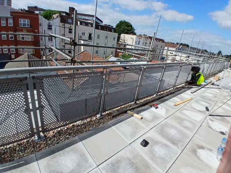 Renewed balcony walkway with new paving slabs and mesh balustrade