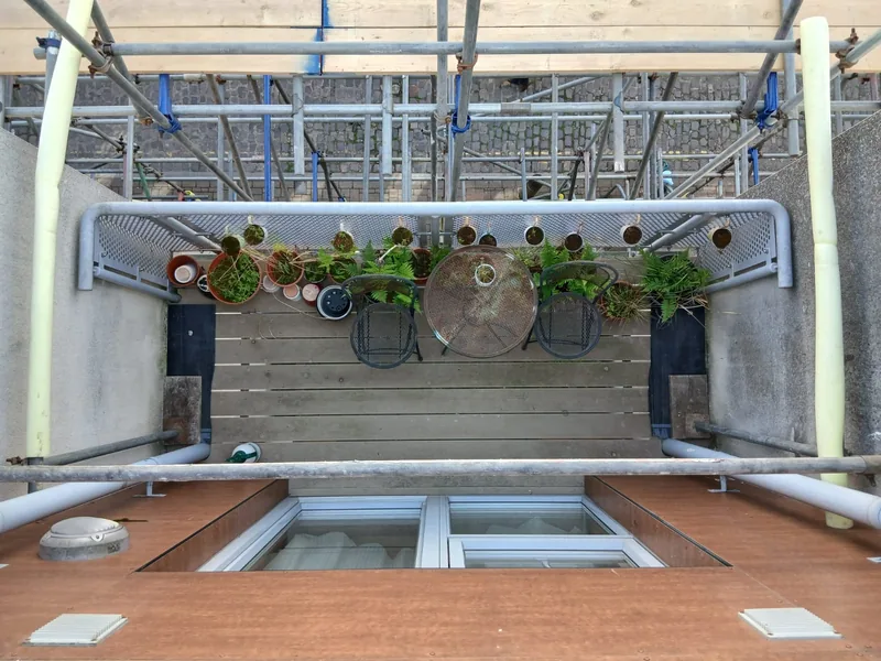 Balcony with failed timber decking beneath scaffolding before the works