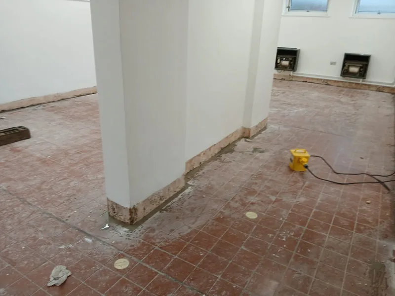 Washroom stripped back to bare walls and old quarry tiles before refurbishment