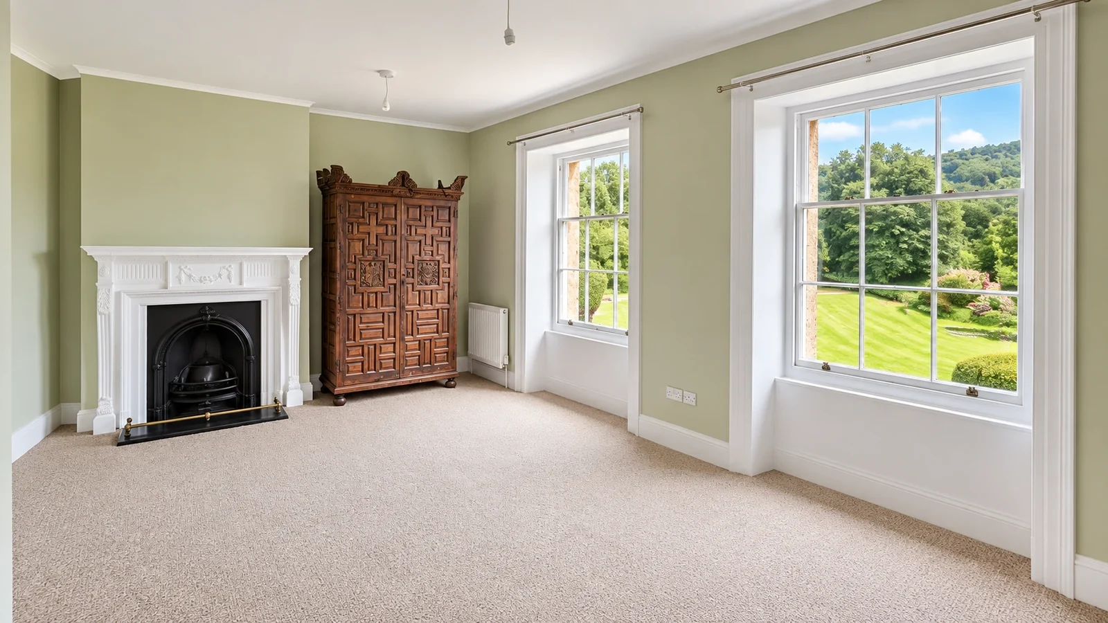 Refurbished drawing room in a country house with a marble fireplace, sash windows and new carpet